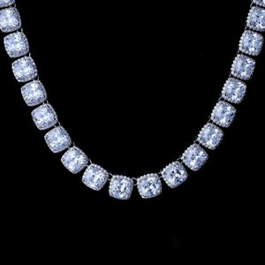 Macro close‑up shot of 10MM Glacier Cushion Clustered Tennis Chain in White Gold, hand‑set VVS flawless simulated cushion diamonds with clustered halo micro pave setting, icy bling hip hop tennis chain necklace flat lay on solid black studio background showcasing brilliant stone sparkle RDRIP JEWELRY