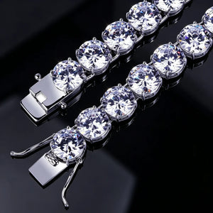 Close‑up comparison view of double lock safety clasp on 10mm silver iced out sparkle tennis bracelet, shot on glossy black reflective surface, large round prong‑set VVS simulated diamond stones, heavy duty safety locking mechanism, silver plated unisex hip hop bling wrist jewelry for men women, RDRIP JEWELRY