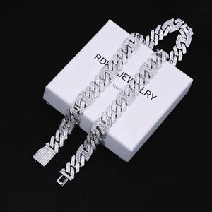 Full overhead flat‑lay shot of two 15mm prong‑set baguette mixed‑stone iced cuban curb chains in white gold finish, complete with fully iced box clasp, laid on branded RDRIP JEWELRY gift box marked SINCE 2016 against textured black leather background, densely hand‑set VVS simulated baguette & round diamonds, heavy full iced‑out men hip‑hop streetwear bling jewelry RDRIP JEWELRY