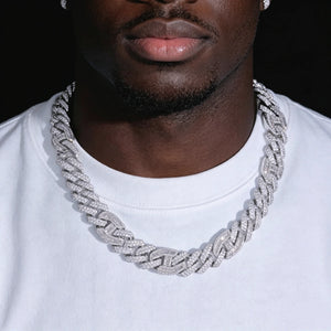 Worn front view shot of 15mm prong‑set baguette mixed‑stone iced cuban curb chain in white gold finish, worn by dark‑skin Black male with slight short stubble beard, model wearing plain crew‑neck white t‑shirt, hand‑set VVS simulated baguette and round cut diamonds, heavy full‑iced curb link hip‑hop statement necklace, studio product photography for men streetwear bling jewelry RDRIP JEWELRY