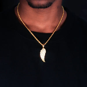 Close‑up neck worn shot of 15mm Iced Micro‑Paved Single Seraph Wing Pendant in yellow gold tone, matched with gold rope chain, fully micro paved sparkling cubic zirconia feather wing charm, men hip‑hop street jewelry on black tee, dark studio background, RDRIP JEWELRY