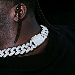 Side close‑up view of the buckle clasp on 16MM Rect Baguette Cuban Link Chain, worn by dark‑skin black man with short neat braids hairstyle, iced‑out mixed rectangular baguette and round flawless VVS simulated diamonds, white gold plated heavy miami cuban hip hop necklace, showing fully encrusted stone‑filled lock detail, dark studio solid black background, RDRIP JEWELRY