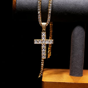 18k gold plated baguette cut iced out cross pendant hanging on jewelry display stand, vvs simulated diamond hip hop tennis chain necklace, bling streetwear men fashion jewelry against solid black background RDRIP JEWELRY