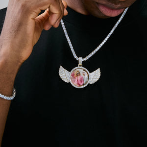 Male model holding gold tone 3D Angle Wing Custom Picture Pendant with iced tennis chain, double photo personalized hip hop pendant close-up shot, RDRIP Jewelry