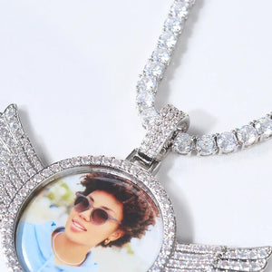 Extreme close-up detail shot of silver 3D Angle Wing Custom Picture Pendant, full pave diamond bezel, encrusted bail and matching iced tennis chain with custom single portrait photo inside, RDRIP Jewelry