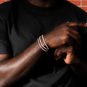 Model wearing stacked 3mm Iced Out Tennis Bracelets in gold, white gold and rose gold finish, prong‑set cubic zirconia simulated diamond unisex hip hop jewelry, men layered bling bracelet wrist stack shot, daily wear fashion statement accessories, RDRIP JEWELRY