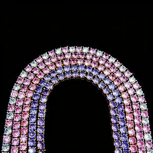4mm Aurora Rainbow Iced Tennis Chain macro shot, pastel pink purple blue ombre gradient VVS simulated CZ diamonds, hand prong‑set stones, 18K gold plated hip hop unisex bling necklace against solid black background, RDRIP JEWELRY