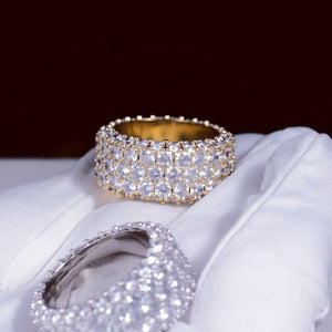 RDRIP JEWELRY 5‑Row Fully Paved Iced Out Eternity Ring gold‑toned and silver‑toned two rings laid on premium white cotton glove, deep dark burgundy bokeh background, heavy 14mm wide prong‑set hip hop eternity band, full‑around meticulously hand‑set flawless VVS simulated diamonds, stunning multi‑faceted light reflection, premium 18K & white gold plated icy bling jewelry for men and women, Prong Cuban family wide statement hip‑hop ring