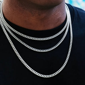 Neck close-up shot of black man layered with 5mm stackable 18k white gold Miami Cuban link chain, polished tangle resistant flexible cuban necklace set for men hip hop street fashion, multi-length stackable design, smooth fully polished uniform links, premium white gold plated anti-tarnish mens urban jewelry, can wear alone or match custom hip hop pendants, handcrafted artisan street bling for casual everyday wear, durable long shine statement cuban chain with lifetime warranty RDRIP JEWELRY