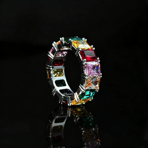 RDRIP JEWELRY Iced Out Rainbow Baguette Eternity Ring silver tone full band ring multicolor baguette cut cubic zirconia hip hop jewelry product photograph on black glossy reflective background showing inner band and stone setting detail for men women bling statement accessory