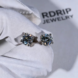 Minimalist Solitaire Round Moissanite Stud Earrings, 4-prong VVS1 hearts and arrows round moissanite studs, 925 sterling silver white gold plated unisex hip hop earrings, closeup photo held on white jewelry glove with branded backdrop RDRIP JEWELRY