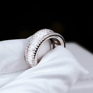 Side angle product shot of 18K gold plated wide baguette cut eternity band ring double row micro pave setting 8mm width VVS grade simulated diamonds full iced out bling hip hop mens statement ring resting on white branded jewelry box RDRIP JEWELRY