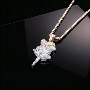 Closeup shot of bling fully paved rose flower pendant resting on black reflective surface, iced out gold plated hip hop necklace embedded with flawless vvs simulated diamonds, premium unisex hiphop streetwear pendant jewelry RDRIP JEWELRY SINCE 2016