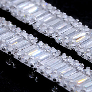 Macro close-up detail shot of 8MM rectangular baguette cut VVS1+ D color moissanite tennis link chain, solid S925 sterling silver white gold finish, hand prong set clear baguette moissanite surrounded by round accent moissanite stones, ultra high clarity brilliant light reflection and rainbow sparkle, 9.25 mohs hardness genuine moissanite not cubic zirconia or diamond simulants, premium hip hop bling necklace craftsmanship closeup, stacked baguette stone structure detail for men streetwear jewelry, luxury i