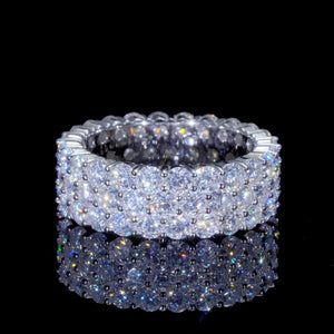 Close‑up shot of iced‑out 3‑row cluster eternity ring with D‑color VVS1+ round hearts and arrows moissanite stones, hand‑set icy hip hop men band ring, genuine 925 sterling silver white gold plated, displayed on black reflective mirror background showing brilliant stone sparkle and light refraction, premium unisex bling statement jewelry RDRIP JEWELRY
