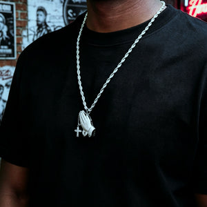 Black male model wearing iced out praying hands pendant with dangling cross on rope chain, s925 silver white gold plated vvs simulated diamonds hip hop faith necklace street style men fashion bling jewelry RDRIP JEWELRY