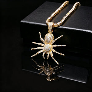 Gold Iced Tarantula Spider Pendant paired with baguette tennis chain on black reflective display surface, fully micro paved flawless VVS simulated diamonds hip hop necklace for men, luxury bling streetwear jewelry showcase RDRIP JEWELRY