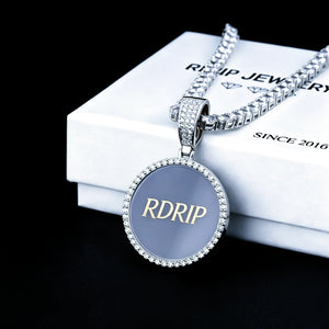 Classic Iced Out Circle Custom Photo Pendant Necklace, silver tone blank sample pendant engraved with RDRIP logo, paired with tennis chain, displayed on RDRIP branded white gift box, solid black background studio shot, personalized hip hop custom memory jewelry, RDRIP JEWELRY
