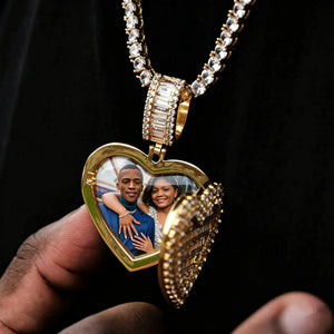 Iced Out Heart Locket Custom Photo Pendant Necklace, gold color open heart locket with custom couple portrait photo inside, displayed with hand model, tennis chain, solid black background, subtle glass cover reflection, openable personalized hip hop memory keepsake jewelry, RDRIP JEWELRY