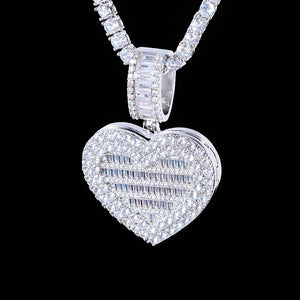 Iced Out Heart Locket Custom Photo Pendant Necklace, white gold tone closed hanging front view, fully iced heart locket with mixed round and baguette cut stones, baguette stone encrusted bail, paired tennis chain against solid black background, openable personalized hip hop custom photo jewelry, RDRIP JEWELRY