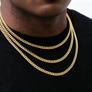 Close-up shot of male model wearing triple layered thin 5mm stackable Miami Cuban link chain in 18k gold plated, polished glossy gold cuban necklace for men hip hop streetwear, available lengths 18 20 24 30 inch, lightweight durable anti-tarnish 18k gold cuban chain perfect for stacking alone or pairing with custom pendant, classic men’s urban hip hop jewelry from RDRIP JEWELRY, smooth flexible tangle-free cuban link design ideal everyday layering necklace for street fashion outfits, premium hand polished