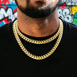 12.2mm thick 18k gold plated Miami Cuban link choker with secure box clasp, two layered stacked curb necklaces on Black man with ultra trimmed short beard, plain black crew neck t-shirt, vibrant colorful urban graffiti wall background, tight interlocking polished cuban links, anti-tarnish shiny gold finish heavy hip hop men jewelry, stackable streetwear gold chain for daily outfit, classic bold icy mens necklace ideal for layering, premium hip hop accessories RDRIP JEWELRY SINCE 2016
