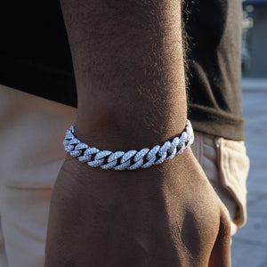 10.5mm full iced out white gold plated cuban link bracelet for men, fully prong hand set flawless VVS simulated diamonds hip hop wrist jewelry, close up outdoor model wearing icy miami cuban bracelet, copper base heavy bling rapper bracelet 7 8 9 inch sizes, luxury streetwear men's wrist chain fashion accessory, gift for hip hop lovers, RDRIP JEWELRY