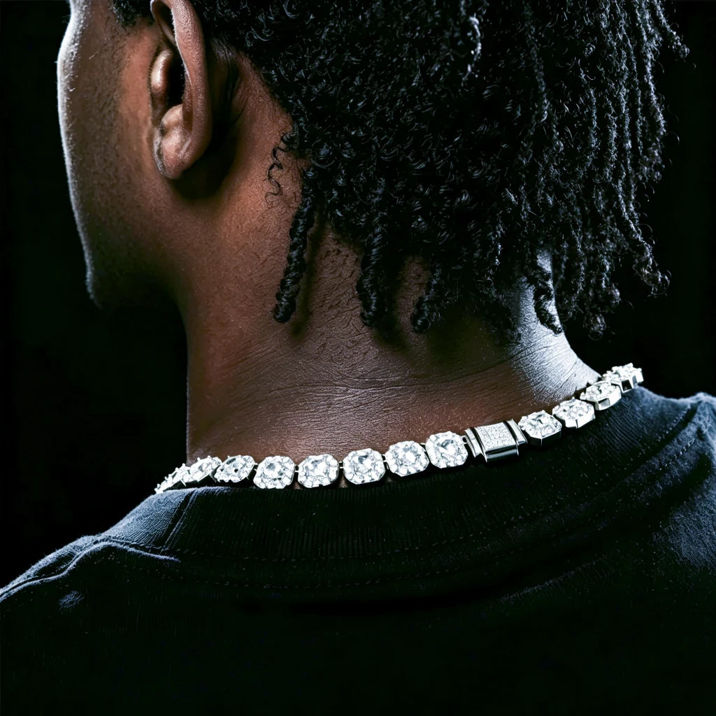 10MM Cushion Clustered Tennis Chain in White Gold back neck close‑up wear shot on male model, highlighting fully iced‑out encrusted box clasp, cushion cluster VVS simulated diamond links, long dreadlocks hairstyle, clean no beard, dark black studio background, real neck wearing effect, icy bling hip‑hop unisex statement neck chain for men RDRIP JEWELRY
