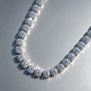 10MM Cushion Clustered Tennis Chain in White Gold close‑up detail shot, VVS simulated diamond cushion cluster links, icy bling hip hop unisex necklace lying flat on seamless grey reflective board, sparkling diamond highlights, premium men women statement bling jewelry RDRIP JEWELRY
