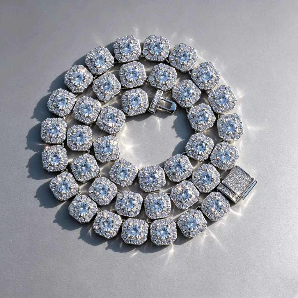 10MM Cushion Clustered Tennis Chain in White Gold top‑down overhead shot, fully coiled cushion cluster tennis necklace with fully iced out box clasp, VVS simulated diamond links, icy bling unisex hip hop jewelry laying flat on seamless edge‑free grey reflective board, sparkling brilliant stones men women statement necklace RDRIP JEWELRY
