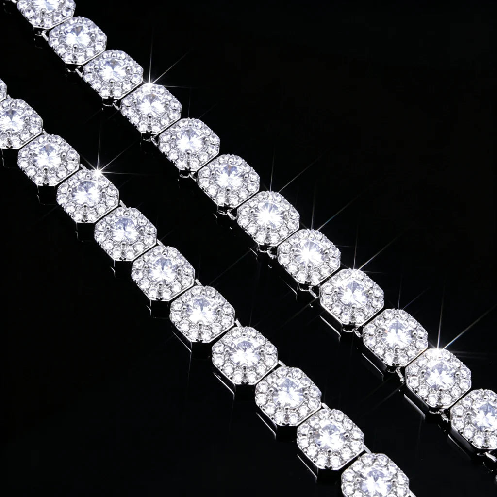 10MM Cushion Clustered Tennis Chain in White Gold double row diagonal close‑up product shot, cushion cluster VVS simulated diamond links arranged in two parallel rows, bright diamond starburst sparkles and long brilliant light rays, icy bling silver tone, displayed on seamless black reflective surface, luxury hip‑hop unisex statement necklace, high magnification jewelry detail showing stone setting and metal framework RDRIP JEWELRY
