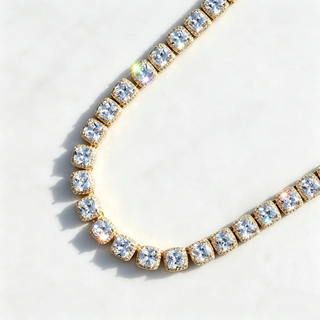 Flat‑lay top‑down product shot of 10MM Glacier Cushion Clustered Tennis Chain in 18K Gold, icy VVS cushion‑cut simulated diamond clustered tennis chain with brilliant sparkling stone reflections, hand prong‑set hip hop bling necklace displayed on subtle textured pure white marble background, premium unisex statement ice jewelry RDRIP JEWELRY
