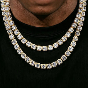 Close‑up shot of men wearing 10MM Glacier Cushion Clustered Tennis Chain in 18K Gold, layered iced out cushion cut simulated diamond hip hop necklace, VVS bling pave cluster stones gold plated chain on dark skin male model against solid black background, premium unisex hip‑hop jewelry statement piece RDRIP JEWELRY
