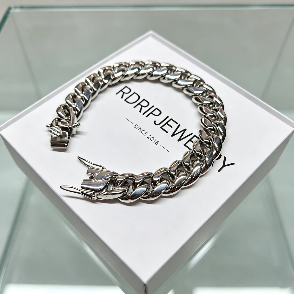 Studio product shot of polished heavy 12mm 18K white gold plated classic Miami cuban link bracelet for men solid stainless steel base triple thick IP white gold plating full coverage between every chain links fully open triple safety box lock clasp display laid flat on branded white packaging box printed RDRIP JEWELRY SINCE 2016 ultra shiny silver reflective finish heavyweight 106g hip hop streetwear bling wrist jewelry tarnish fade resistant durable everyday stacking accessory affordable substitute 