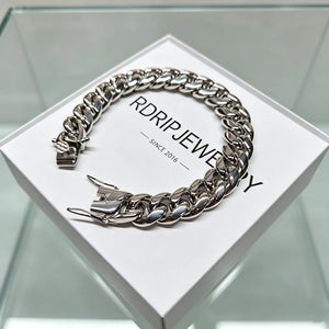 Studio product shot of polished heavy 12mm 18K white gold plated classic Miami cuban link bracelet for men solid stainless steel base triple thick IP white gold plating full coverage between every chain links fully open triple safety box lock clasp display laid flat on branded white packaging box printed RDRIP JEWELRY SINCE 2016 ultra shiny silver reflective finish heavyweight 106g hip hop streetwear bling wrist jewelry tarnish fade resistant durable everyday stacking accessory affordable substitute 