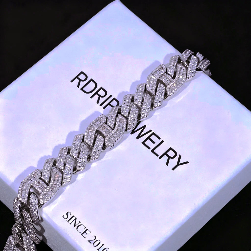 12mm Prong Set Iced Baguette Curb Bracelet White Gold Plated diagonal angle shot resting on branded RDRIP white jewelry gift box, hand prong set rectangular VVS simulated baguette diamond thick curb link bracelet, fully iced out bling cuban wrist chain with full stone coverage, luxury hip hop men's jewelry gift display, shiny reflective icy streetwear accessory perfect for gift giving RDRIP JEWELRY
