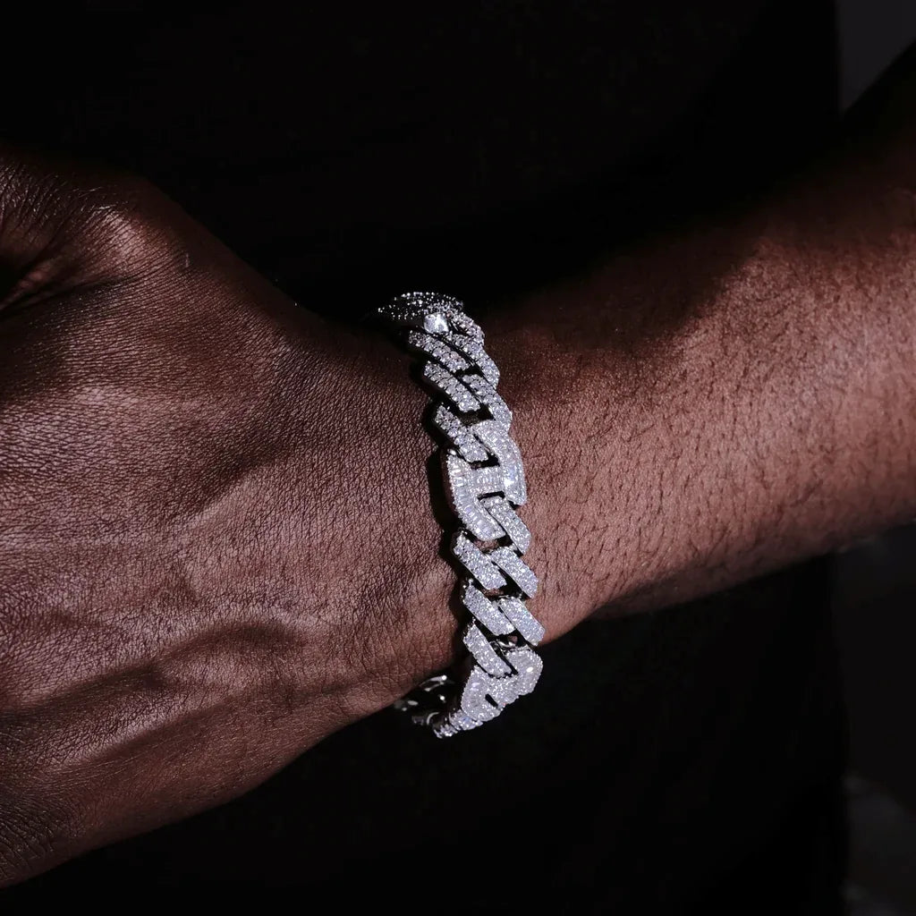 12mm Prong Set Iced Baguette Curb Bracelet White Gold Plated on men dark skin wrist closeup shot, fully flooded flawless VVS simulated rectangular baguette diamond curb link wrist chain, handmade prong setting full iced clasp thick hip hop streetwear jewelry for men, shiny icy bling mens cuban bracelet RDRIP JEWELRY
