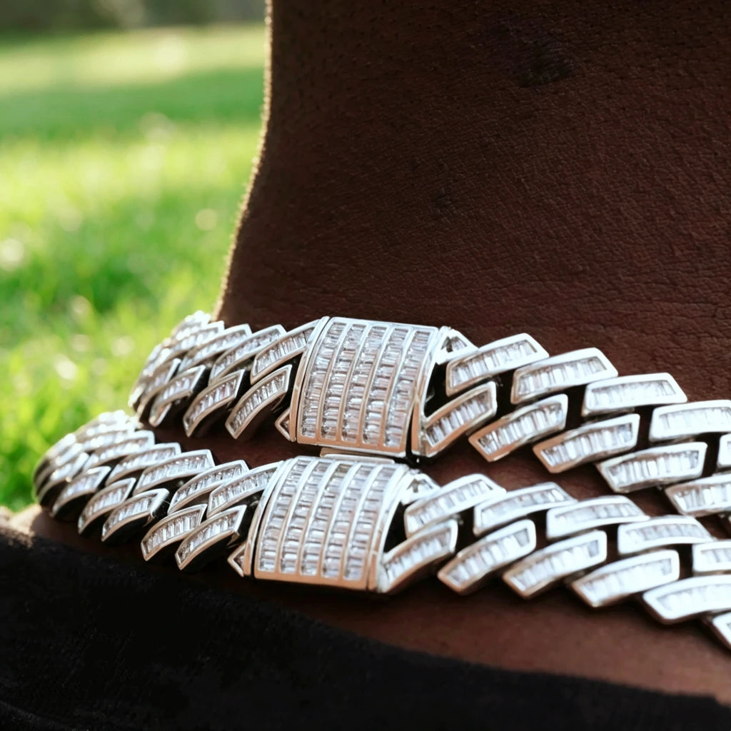 14MM Baguette Channel‑Set Miami Cuban Link Necklace macro close‑up, 18K white gold plated full iced‑out hip hop chain for men, hand‑set flawless VVS simulated baguette stones, detailed shot of fully encrusted box clasp lock, two stacked chains resting on deep‑skin neck, soft green grass outdoor background, heavy bling rapper streetwear jewelry RDRIP JEWELRY
