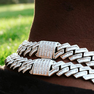 14MM Baguette Channel‑Set Miami Cuban Link Necklace macro close‑up, 18K white gold plated full iced‑out hip hop chain for men, hand‑set flawless VVS simulated baguette stones, detailed shot of fully encrusted box clasp lock, two stacked chains resting on deep‑skin neck, soft green grass outdoor background, heavy bling rapper streetwear jewelry RDRIP JEWELRY
