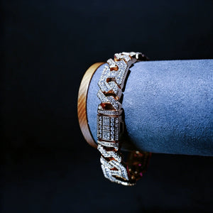 Studio display shot of 14mm gold plated iced out geometric polygon cuban link bracelet for men, hollow multi‑sided links fully prong‑set with flawless VVS simulated CZ diamonds, micro pave icy hip‑hop bling wrist jewelry, bracelet resting on grey suede display stand against solid black background, premium baller‑style rapper statement bracelet RDRIP JEWELRY
