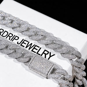 Close up shot of 15mm 5-Row Fully Paved Iced Cuban Link Necklace with fully iced out prong-set clasp, flawless VVS simulated diamond stones all over chain and lock, silver 18K white gold plated heavy Miami cuban chain laid on branded white jewelry box printed RDRIP JEWELRY, solid pure black background, premium handcrafted hip hop bling men's rapper jewelry available in 18 20 24 inch lengths RDRIP JEWELRY
