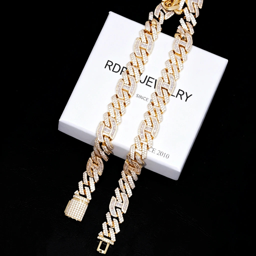 Full length overhead lay‑flat shot of two 15mm prong‑set mixed‑stone iced cuban curb necklaces resting on white branded gift box RDRIP JEWELRY SINCE 2016, 18K gold plated pure copper men hip‑hop jewelry, hand‑set baguette and round VVS simulated diamonds, full iced‑out heavy curb chain showing complete links and box clasp hardware, dark textured background premium streetwear bling RDRIP JEWELRY
