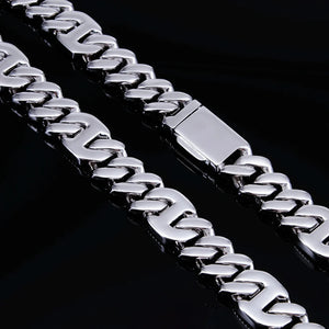 Macro close‑up hardware shot of 15mm prong‑set baguette mixed‑stone iced cuban curb chain in white gold finish, displaying polished solid box safety clasp and smooth curb link structure, high‑gloss reflective metal surface against deep solid black background, premium heavy‑duty hip‑hop men necklace locking mechanism detail shot RDRIP JEWELRY
