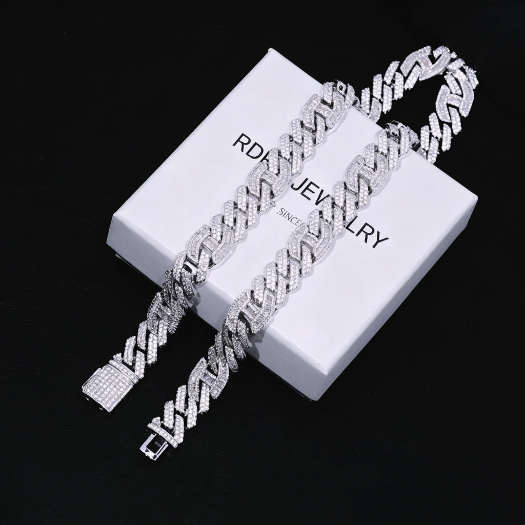 Full overhead flat‑lay shot of two 15mm prong‑set baguette mixed‑stone iced cuban curb chains in white gold finish, complete with fully iced box clasp, laid on branded RDRIP JEWELRY gift box marked SINCE 2016 against textured black leather background, densely hand‑set VVS simulated baguette & round diamonds, heavy full iced‑out men hip‑hop streetwear bling jewelry RDRIP JEWELRY
