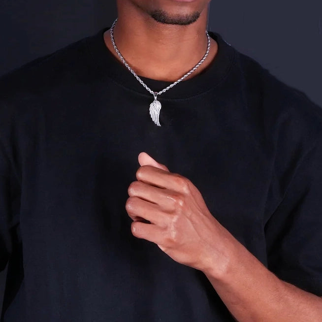 Full upper‑body model wearing view of 15mm Iced Micro‑Paved Single Seraph Wing Pendant silver tone, paired with silver rope chain, micro paved cubic zirconia wing charm, men hip‑hop street jewelry with black t‑shirt, dark studio backdrop, RDRIP JEWELRY
