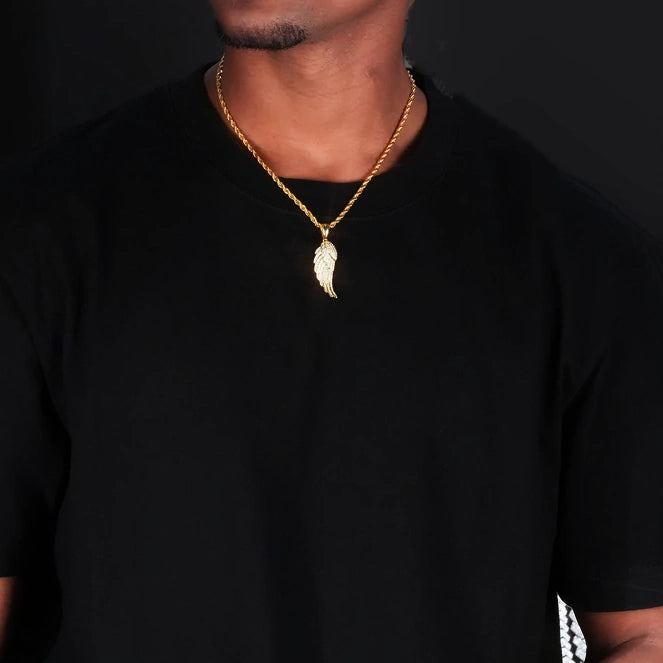 Upper‑body model wearing view of 15mm Iced Micro‑Paved Single Seraph Wing Pendant yellow gold tone, paired with gold rope chain, micro‑set cubic zirconia feather wing charm, men hip‑hop street necklace on plain black t‑shirt, dark solid studio background, RDRIP JEWELRY
