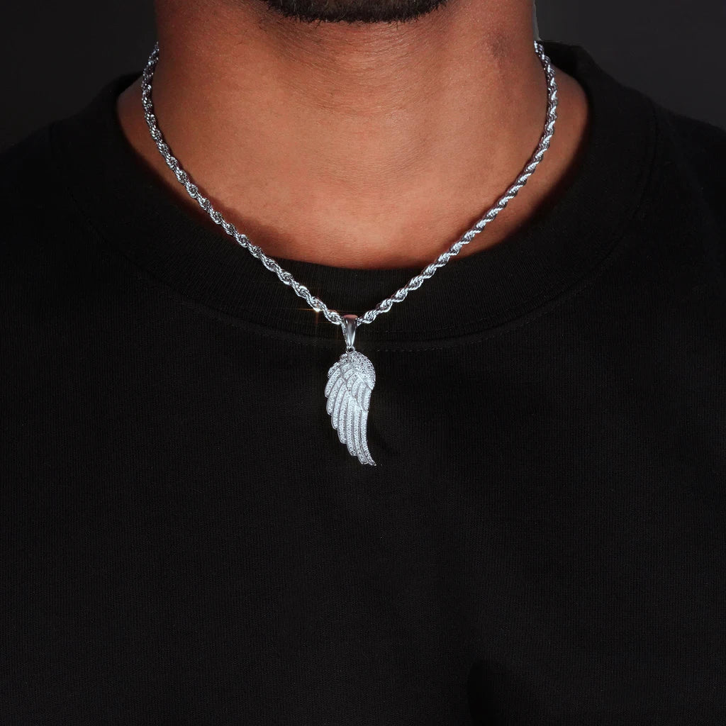 Model neck worn shot of 15mm Iced Micro‑Paved Single Seraph Wing Pendant in silver tone, pendant matched with silver rope chain, fully micro paved cubic zirconia hip hop wing charm, male street style outfit with black tee, dark studio background, RDRIP JEWELRY
