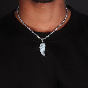 Model neck worn shot of 15mm Iced Micro‑Paved Single Seraph Wing Pendant in silver tone, pendant matched with silver rope chain, fully micro paved cubic zirconia hip hop wing charm, male street style outfit with black tee, dark studio background, RDRIP JEWELRY
