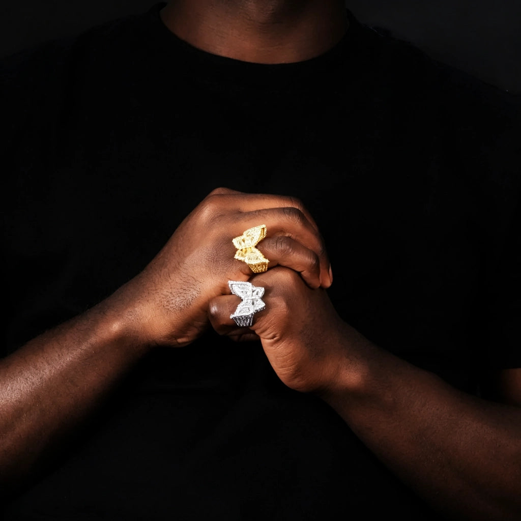 18K gold‑plated iced out baguette butterfly ring worn on model hands, gold and silver two tone fully micro pave cubic zirconia rhinestone 3D butterfly hip hop statement rings for men, heavy bling diamond‑look jewelry on dark skin model with black t‑shirt dark studio background RDRIP JEWELRY
