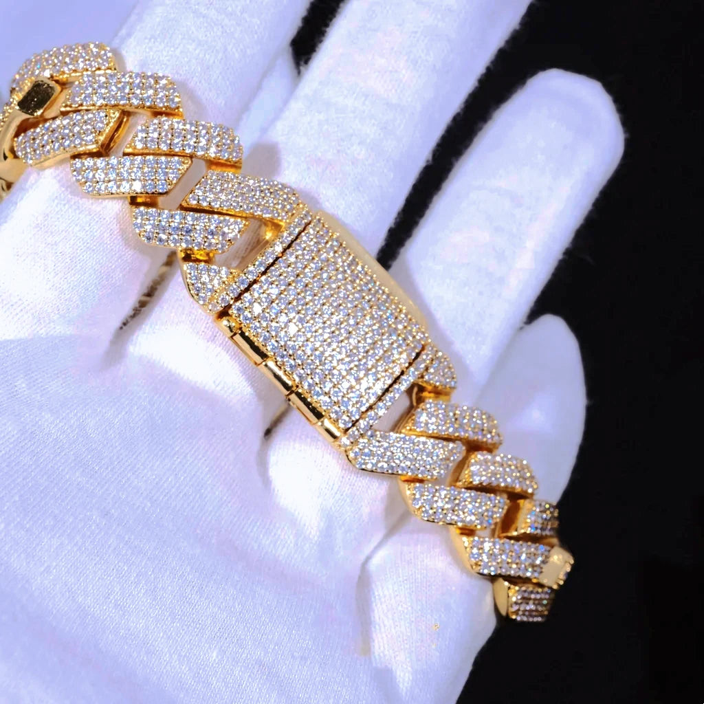 Extreme close-up micro shot of 19mm Full Iced Out Prong Cuban Link Bracelet in shiny 18K gold plating, displayed on soft white jewelry handling gloves against solid black background. Every cuban link and wide rectangular box clasp fully packed with lab-tested flawless VVS simulated diamonds, crafted with brand-new upgraded prong setting technology, solid copper core handcrafted to deliver bright icy reflective shine. Heavy oversized hip hop bling statement wrist jewelry for men and women, scratch & tarnish 